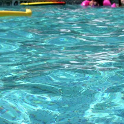 A close up of a swimming pool with people swimming in it.