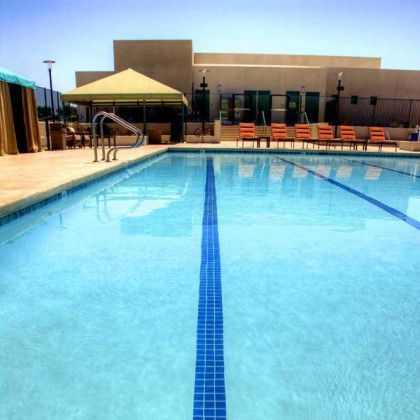 A large swimming pool with a canopy and chairs around it