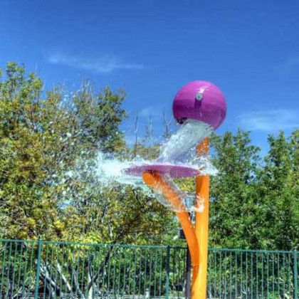 A purple ball is spraying water from a water fountain.