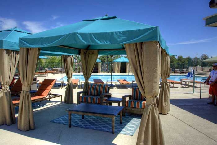 A man standing in front of a pool under a canopy.