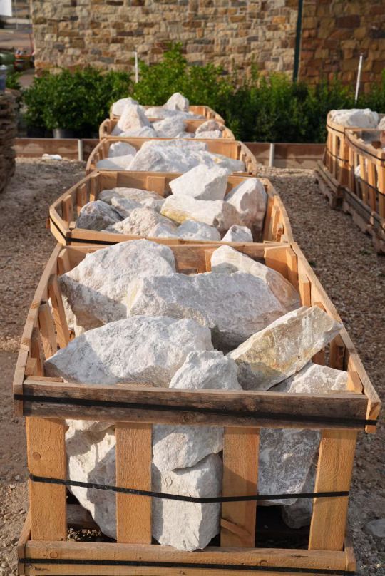 A row of wooden crates filled with white rocks.