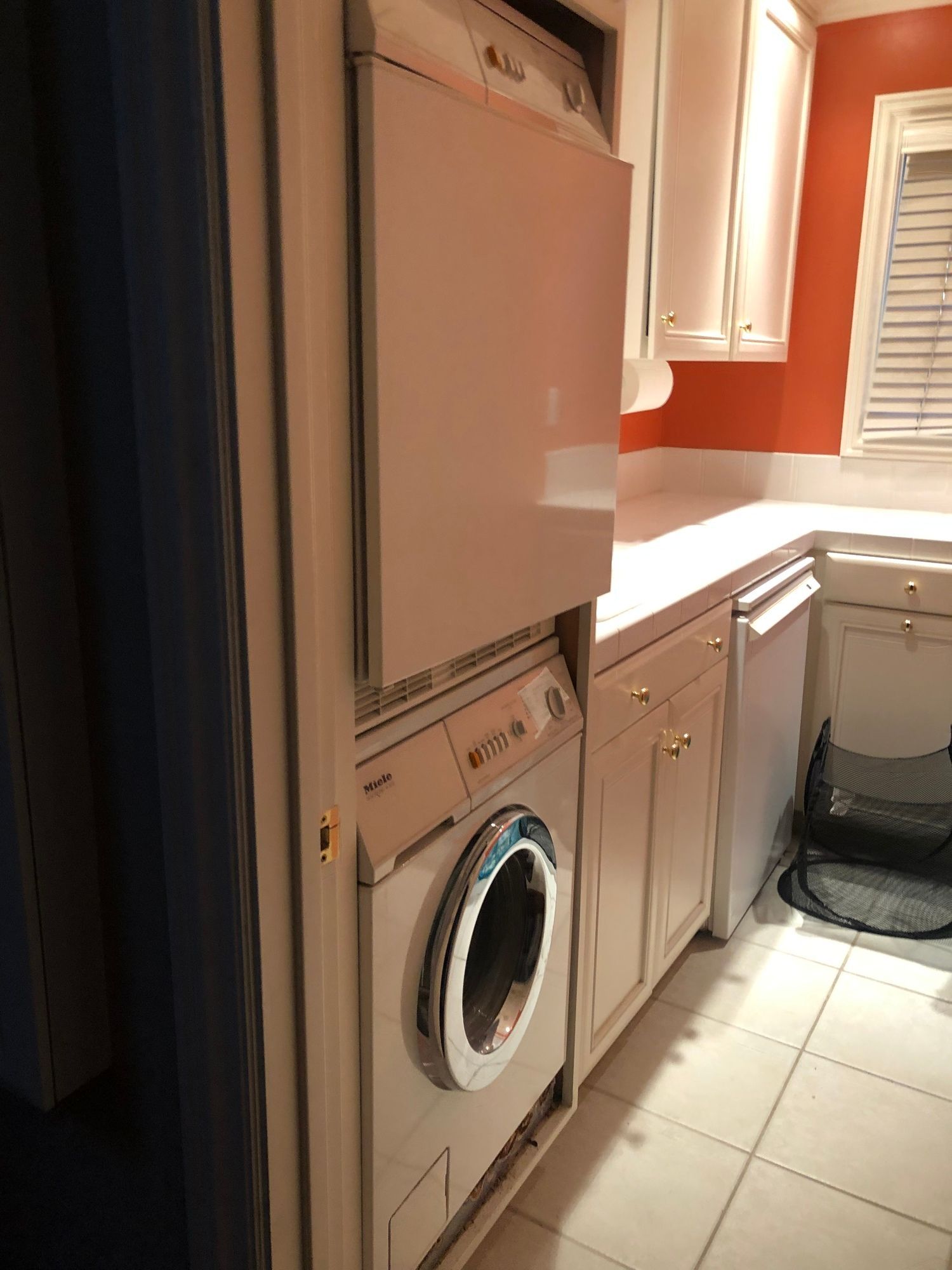 a laundry room with a washer and dryer stacked on top of each other