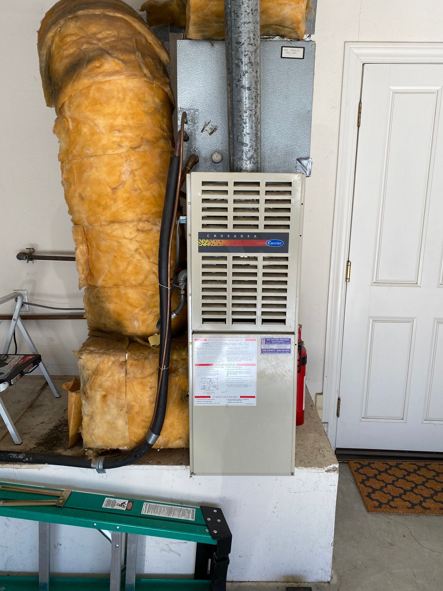 a ladder is sitting next to a heater in a garage .