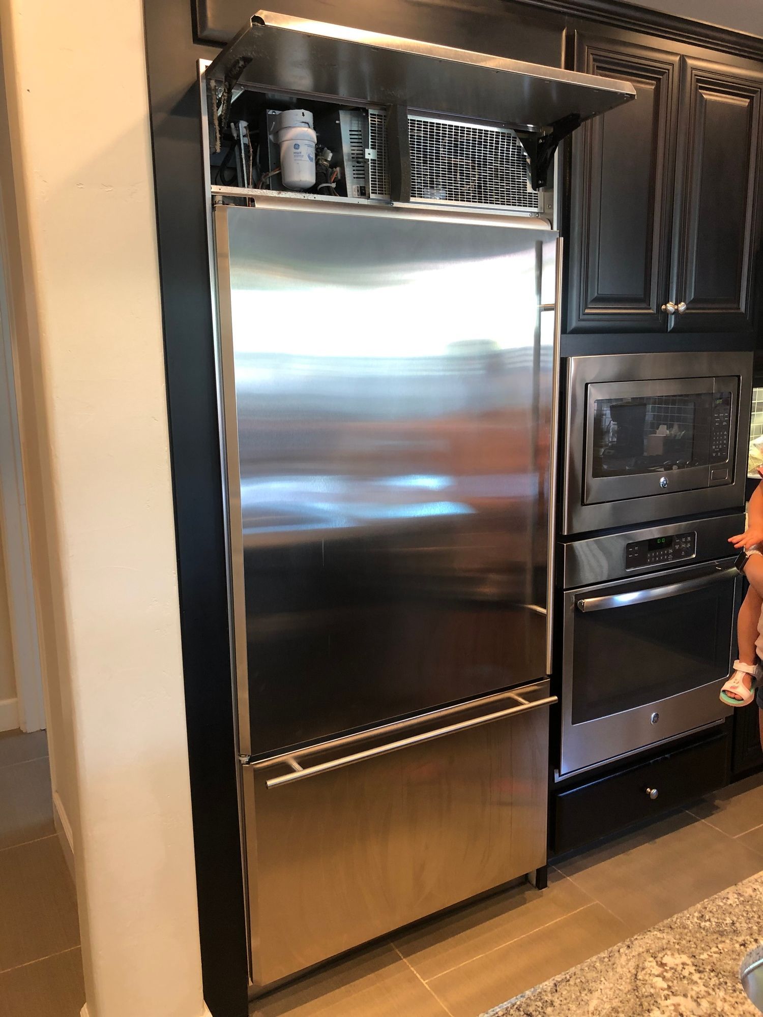 a stainless steel refrigerator freezer is sitting in a kitchen next to a microwave oven .