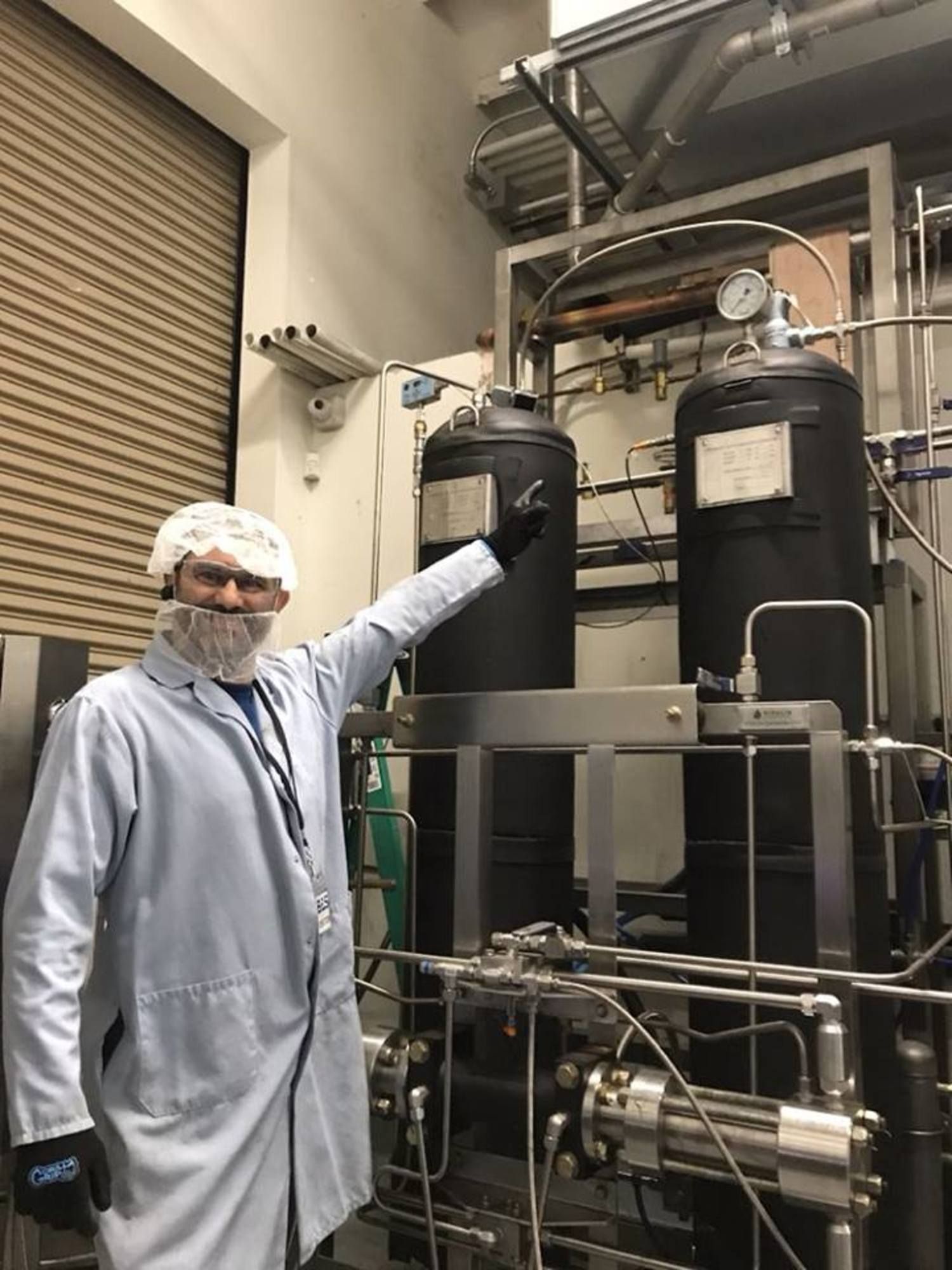 a man in a lab coat is standing in front of a machine .
