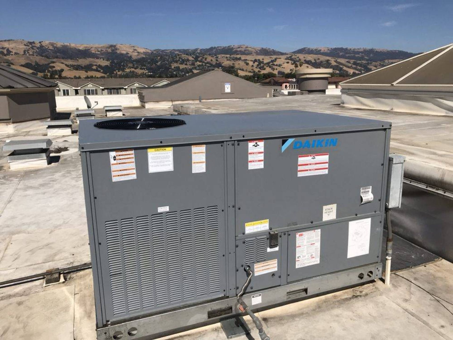 a daikin air conditioner is sitting on top of a roof .