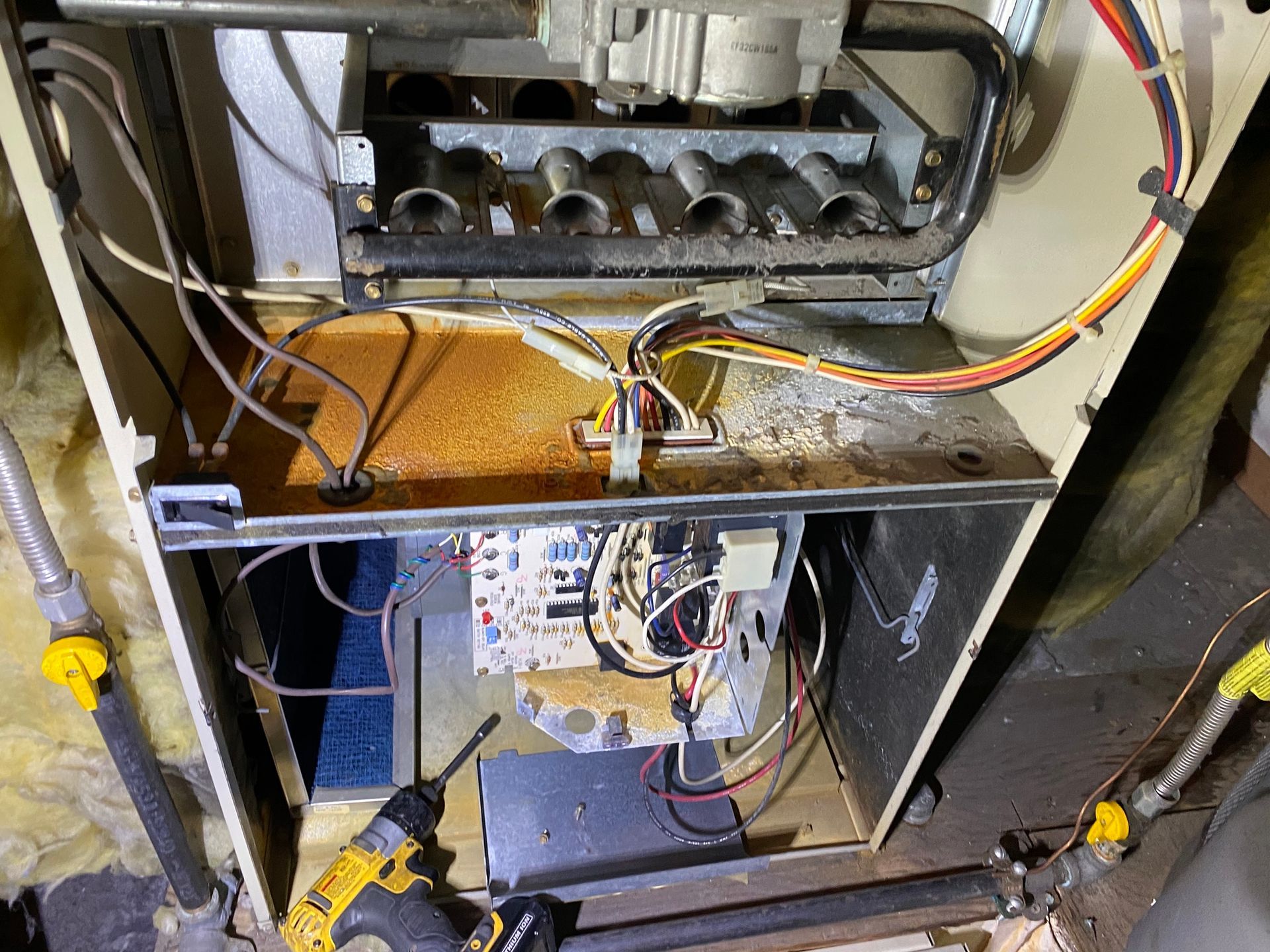 a person is working on a heating system with a drill .