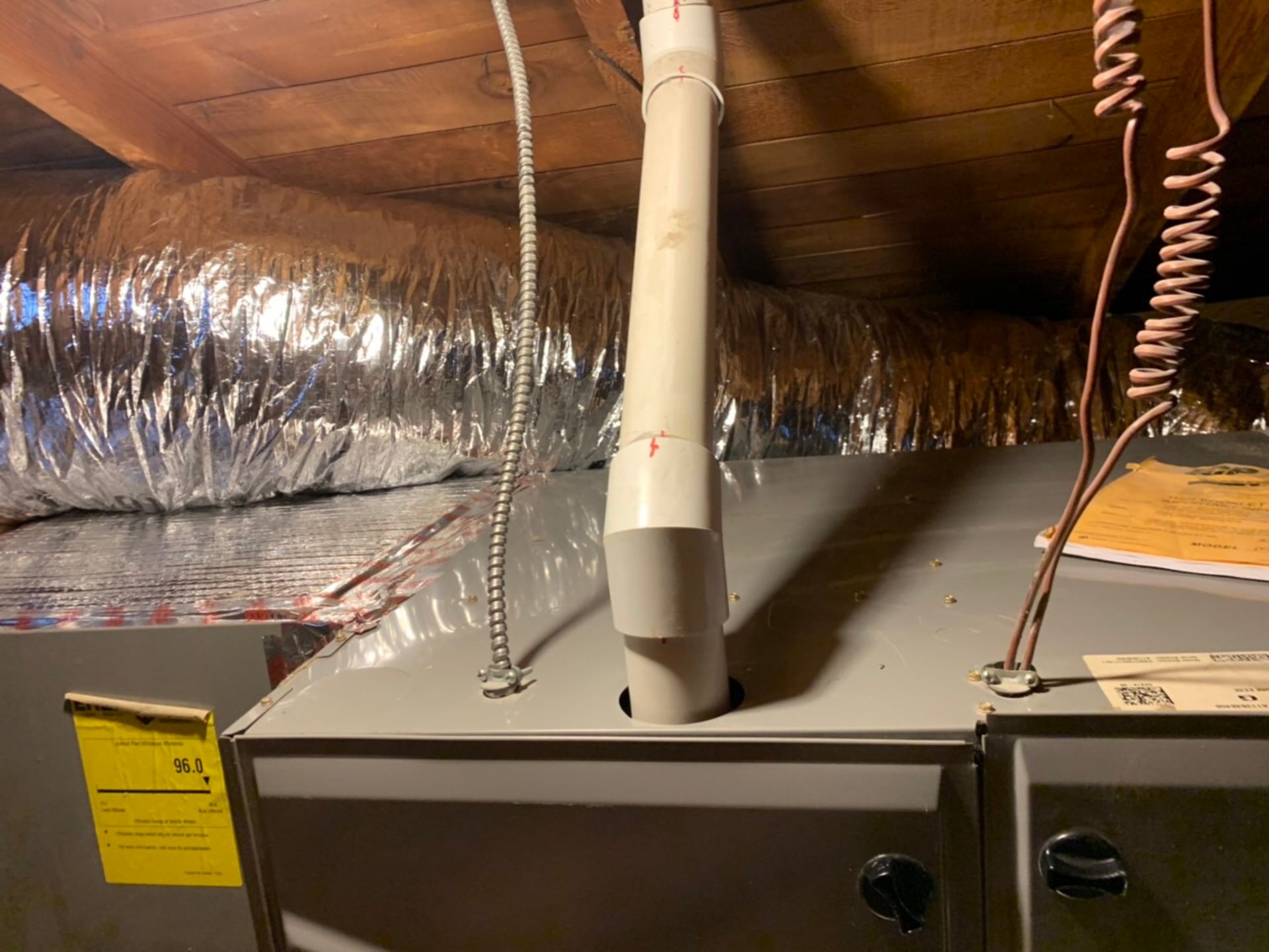 an air conditioner is sitting in the attic of a house .