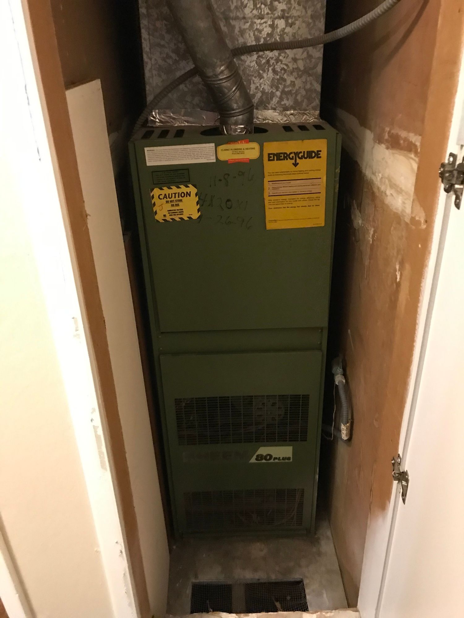 a green air conditioner is sitting in a closet next to a door .