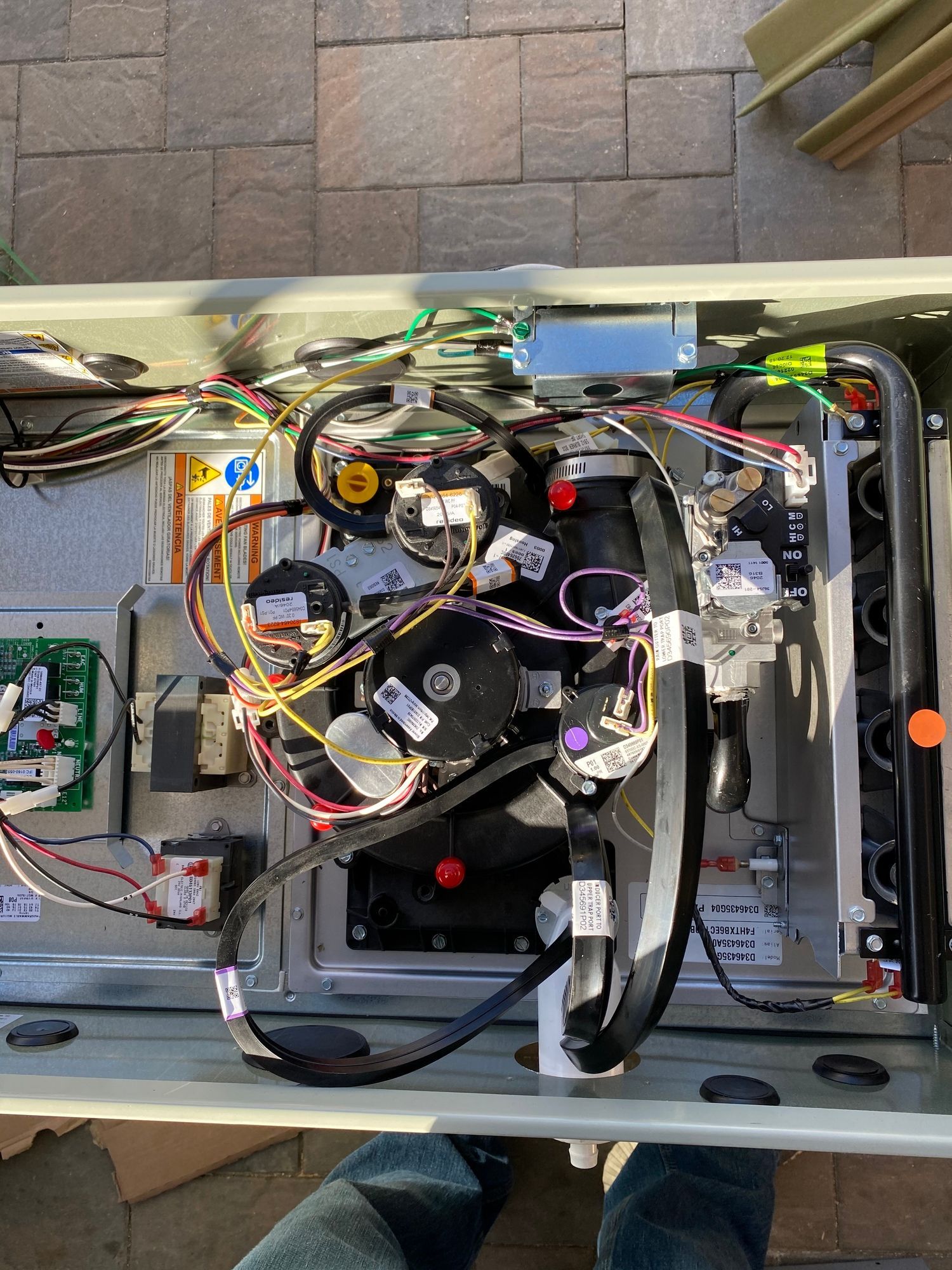 a person is standing next to a box with a lot of wires coming out of it .