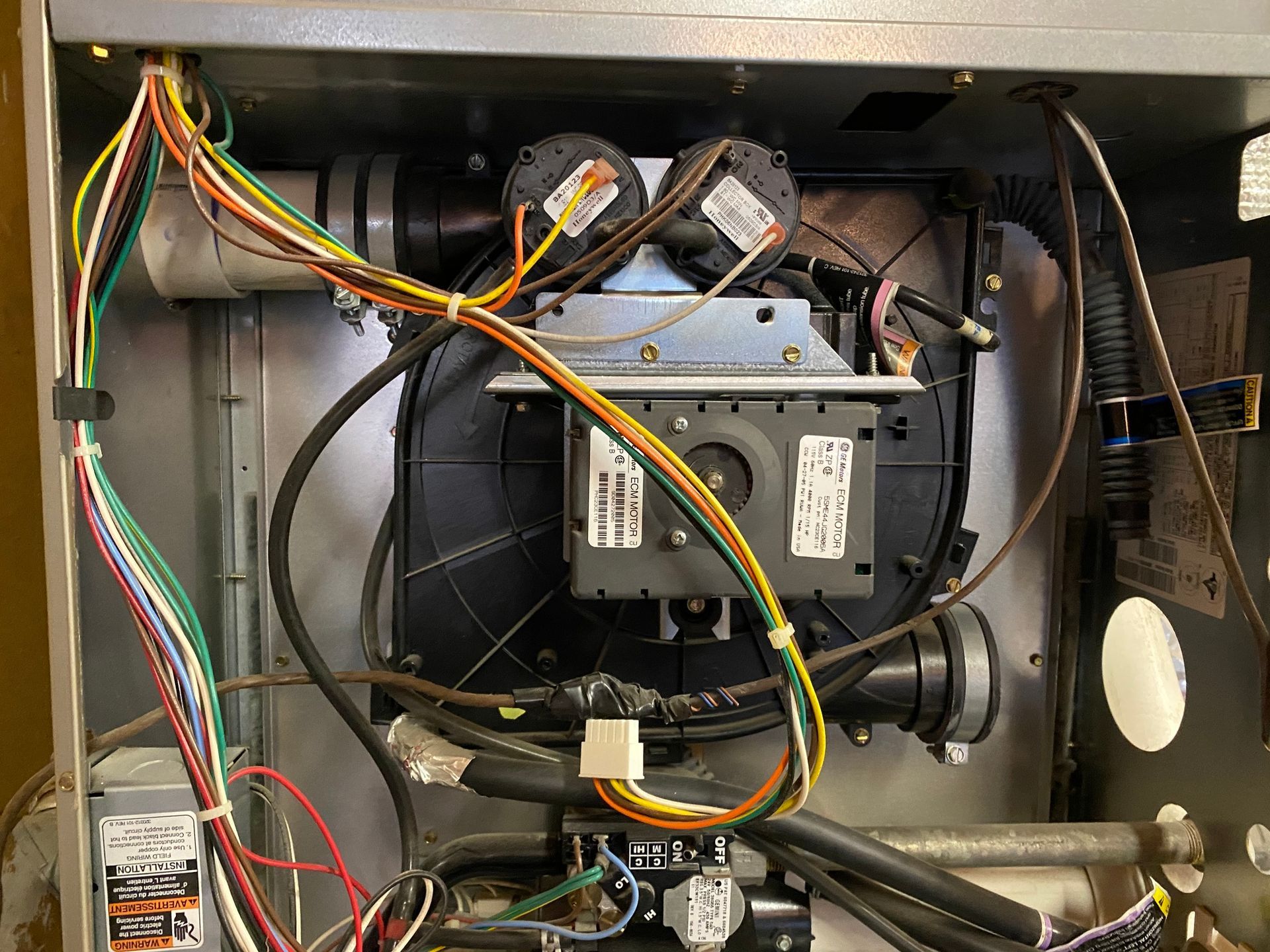 the inside of a microwave oven with a lot of wires coming out of it .
