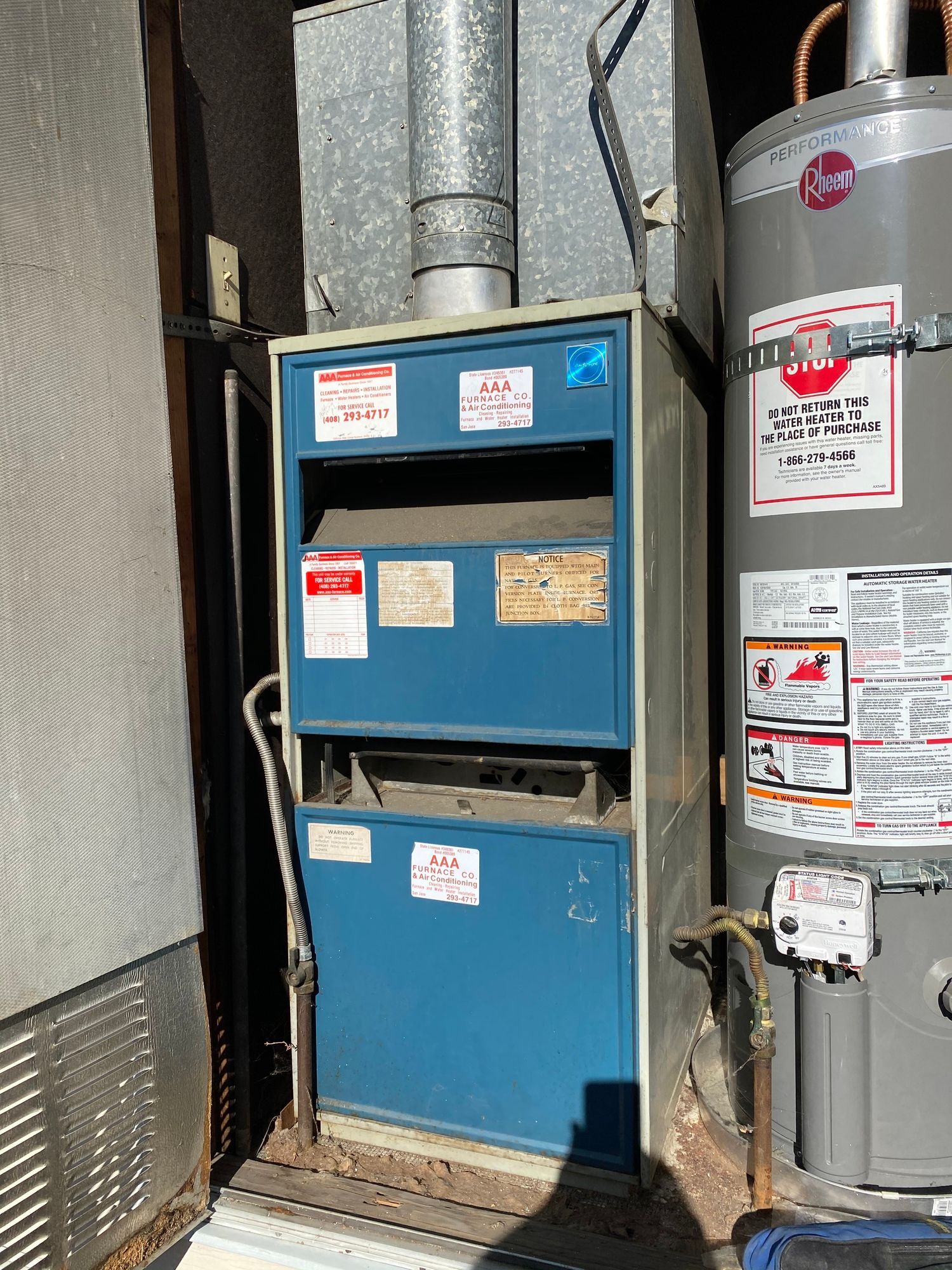a water heater and an air conditioner are sitting next to each other on the side of a building .