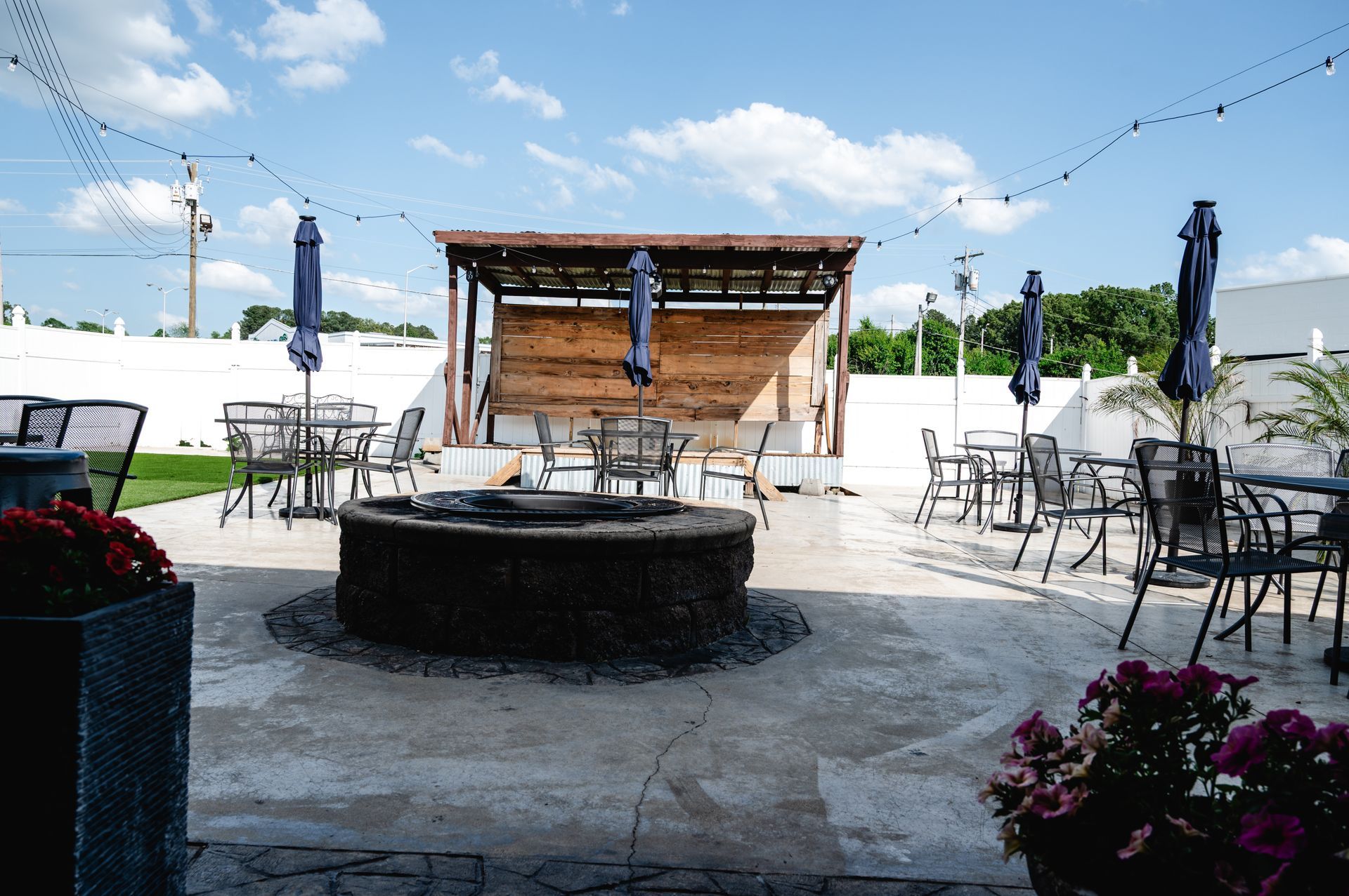 A patio with tables and chairs and a fire pit