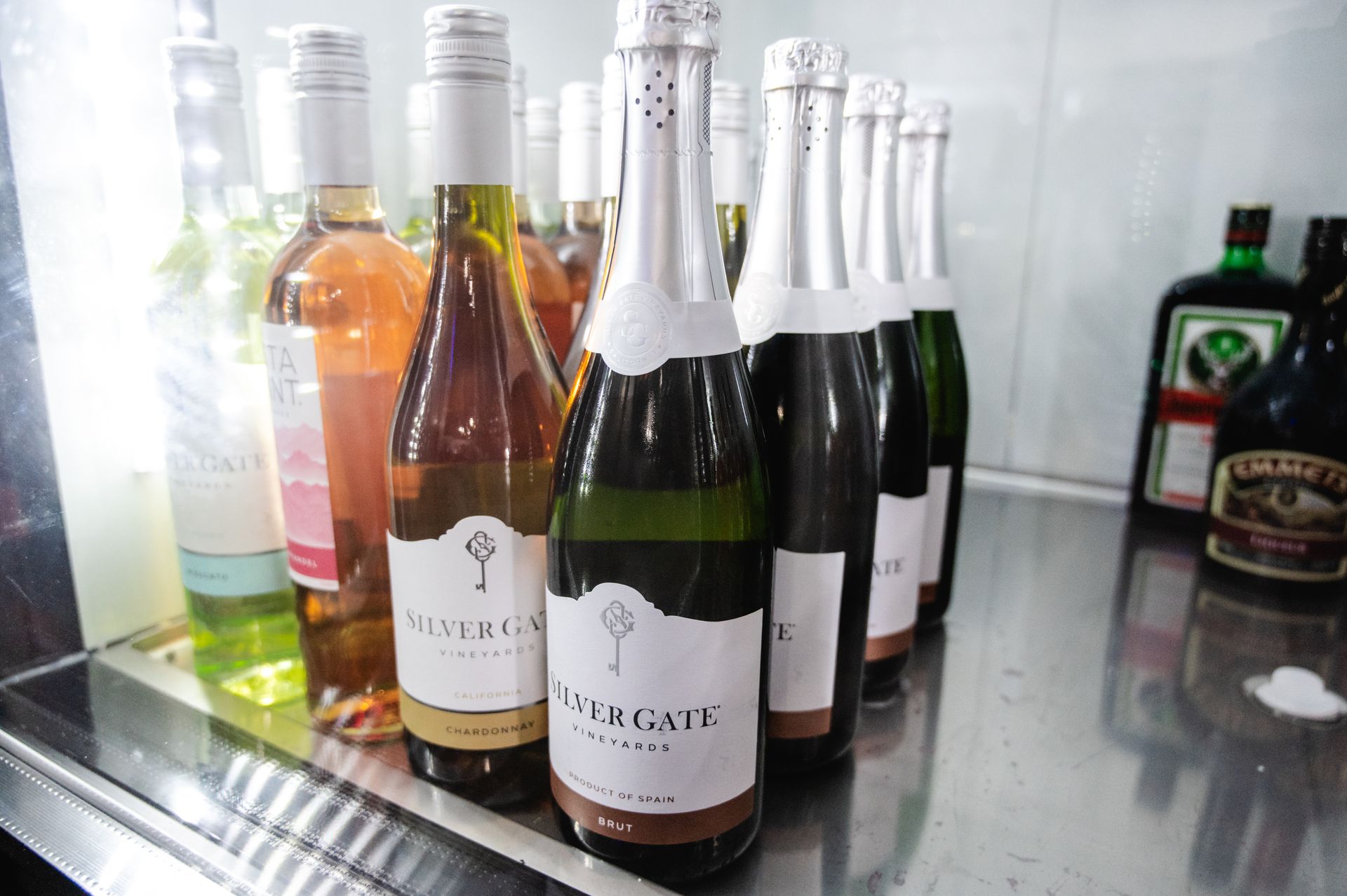 A bunch of bottles of wine are sitting on a counter.
