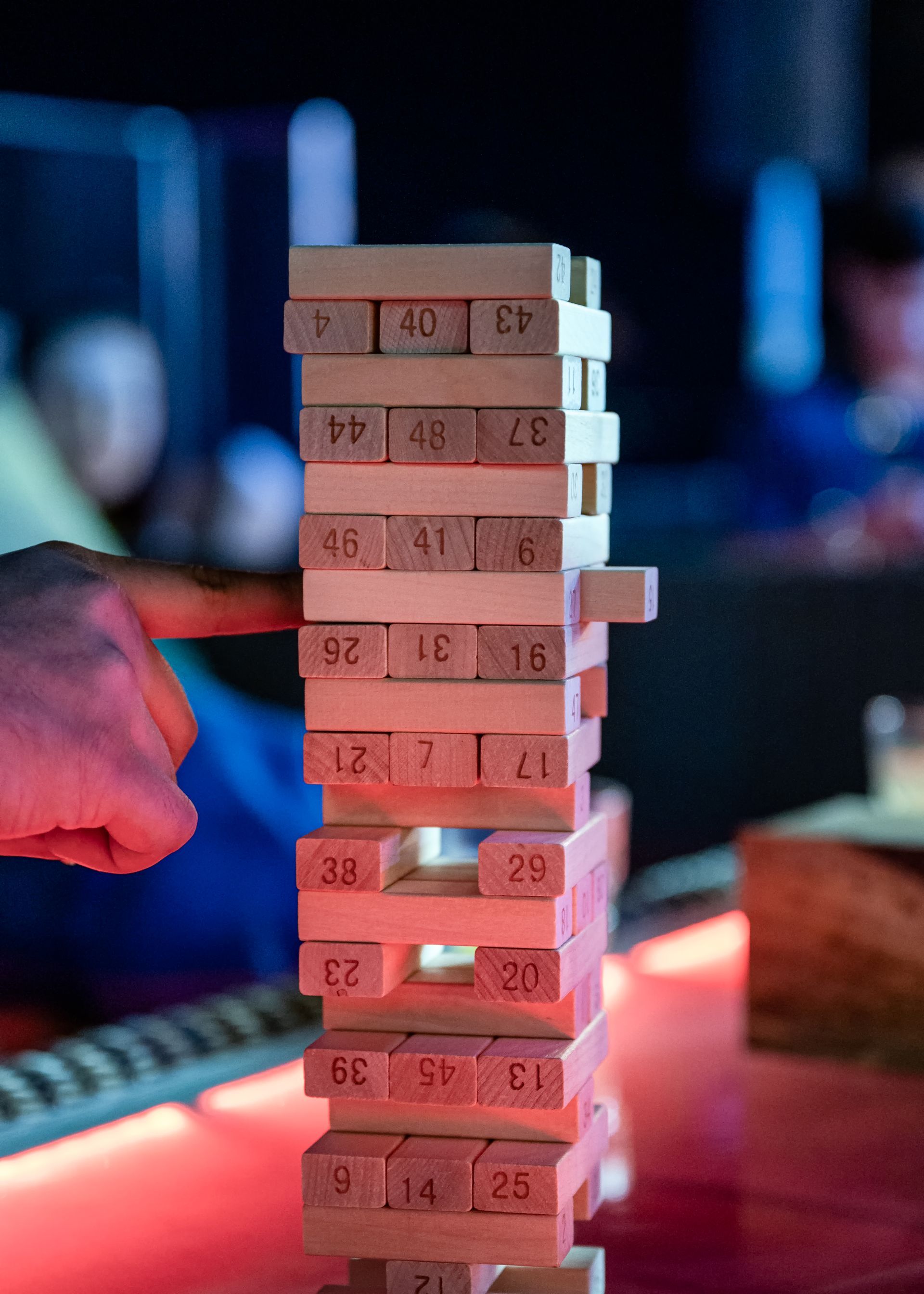 A person is playing a game of jenga with wooden blocks on a table.