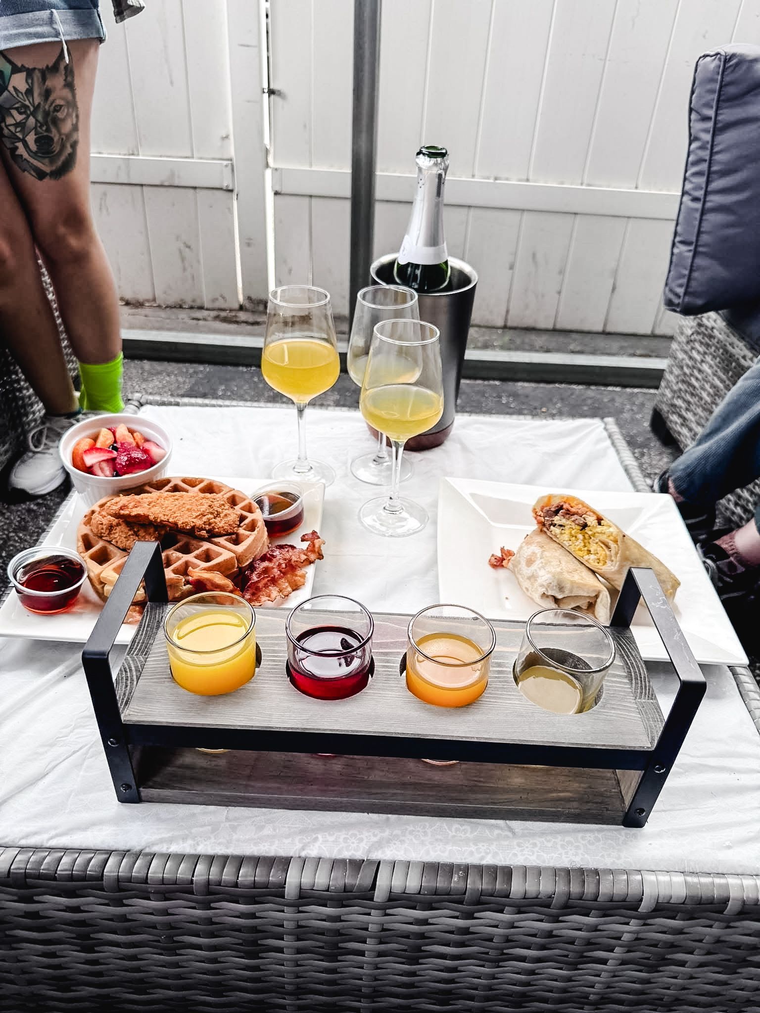 A table with a tray of food and wine glasses on it.