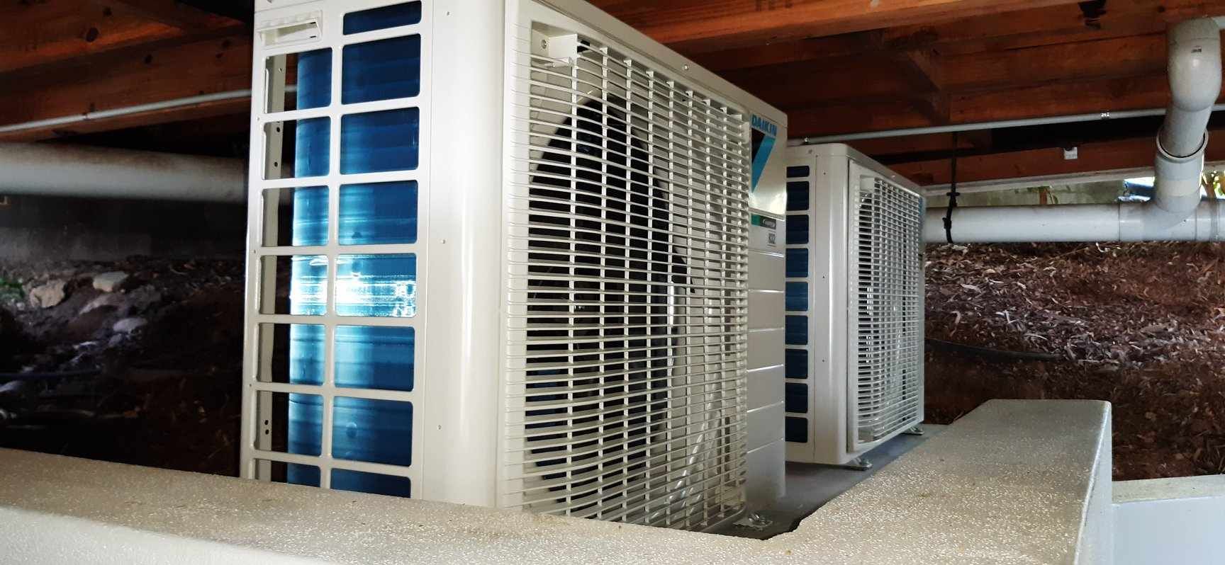 Two Air Conditioners Are Sitting Under a Ceiling in A Basement — McGuire Air & Refrigeration In Paget, QLD