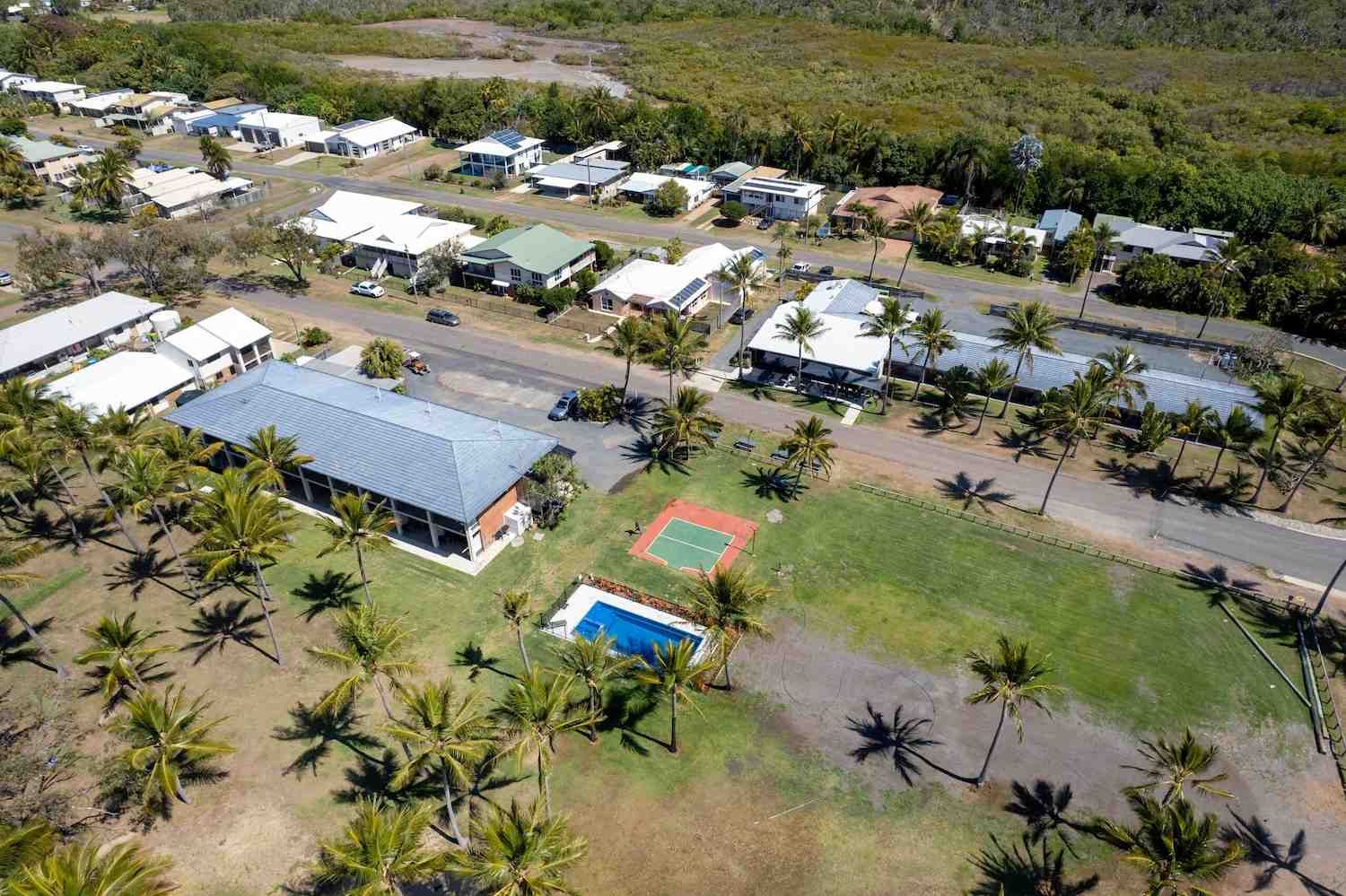 An Aerial View of A Residential Area with A Swimming Pool and Palm Trees — McGuire Air & Refrigeration In Sarina, QLD