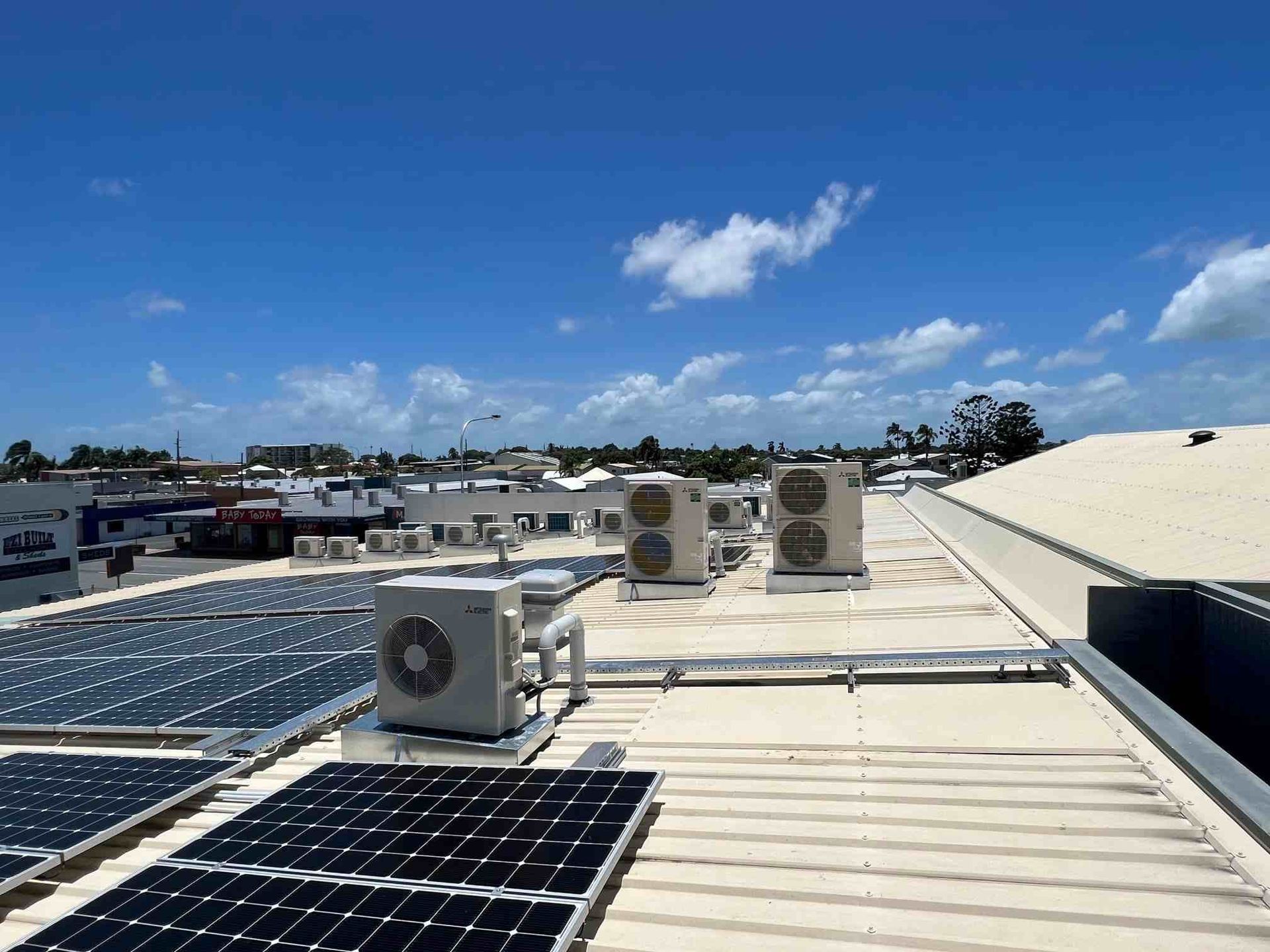 A Roof with Solar Panels and Air Conditioners on It — McGuire Air & Refrigeration In Walkerston, QLD