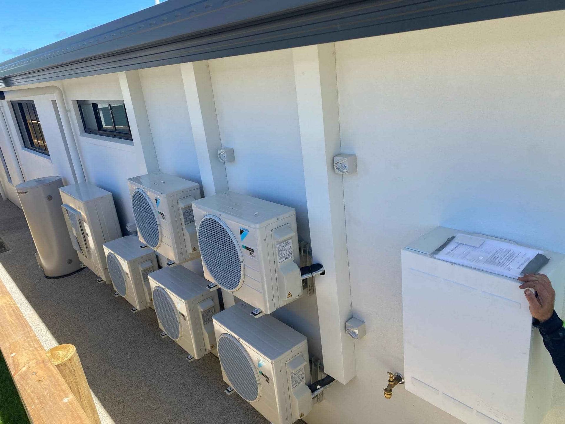 A Row of Air Conditioners Are Lined up On the Side of A Building — McGuire Air & Refrigeration in Proserpine, QLD