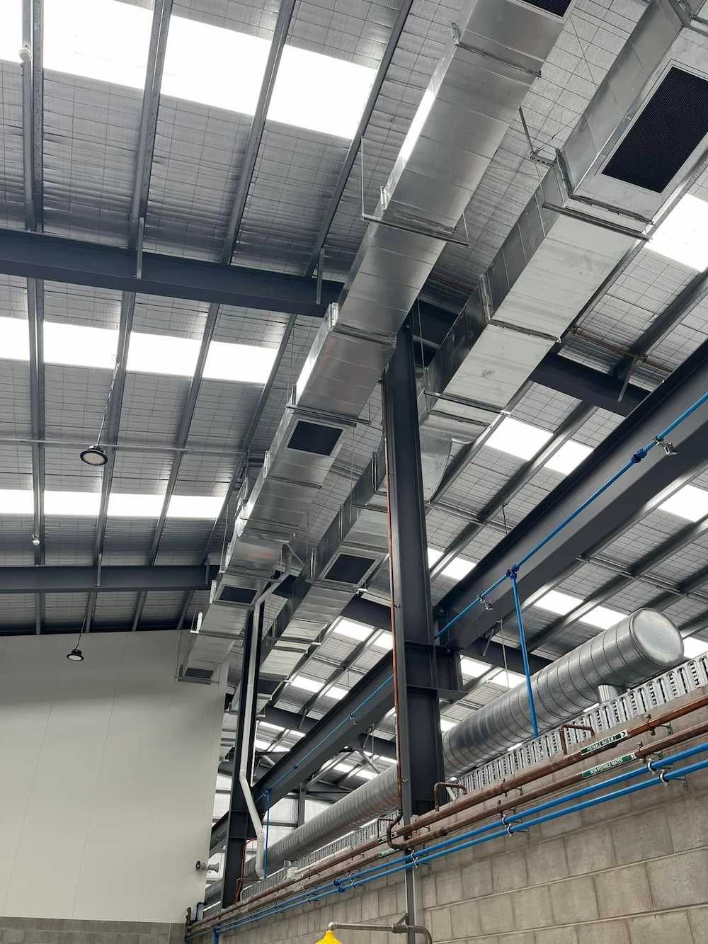 There Are a Lot of Pipes Hanging from The Ceiling of A Building — McGuire Air & Refrigeration In Paget, QLD