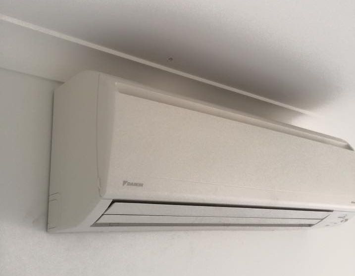 A White Air Conditioner Is Hanging from The Ceiling in A Room — McGuire Air & Refrigeration In Paget, QLD