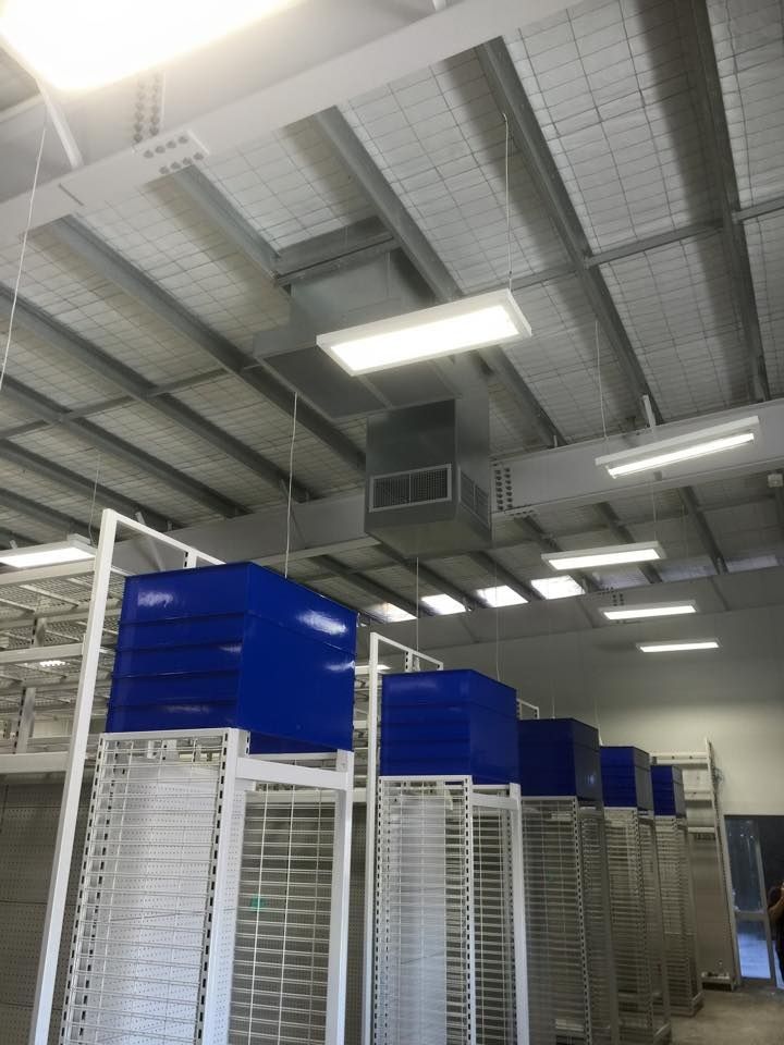 A Warehouse with A Lot of Shelves and Blue Boxes — McGuire Air & Refrigeration In Sarina, QLD
