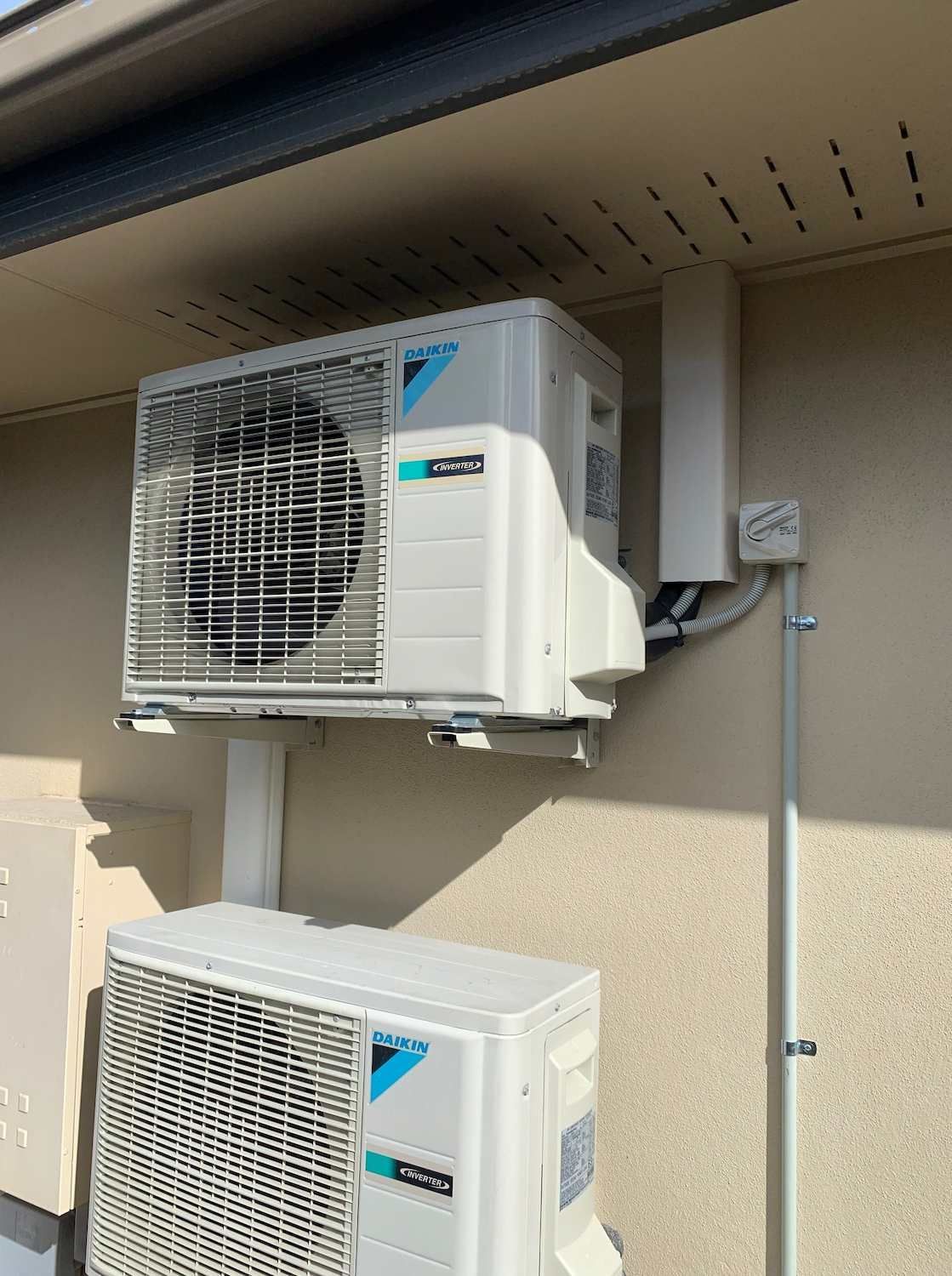 Two Air Conditioners Are Mounted on The Side of A Building — McGuire Air & Refrigeration In Paget, QLD