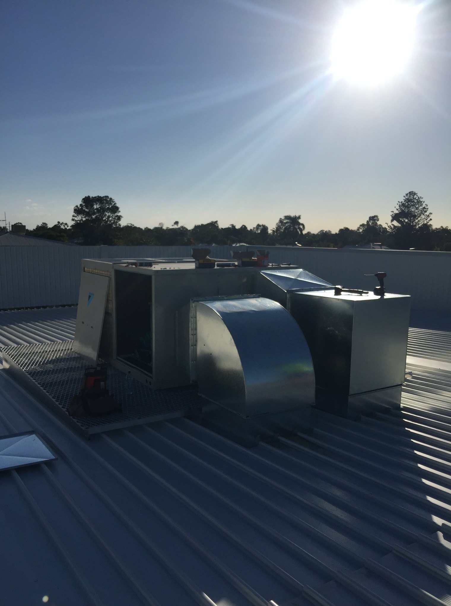 The Sun Is Shining Brightly on The Roof of A Building — McGuire Air & Refrigeration In Paget, QLD