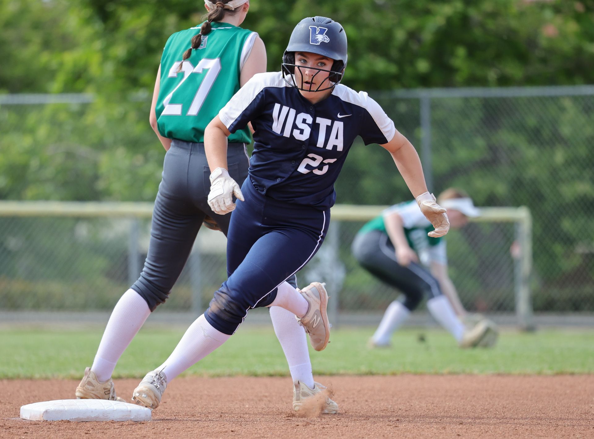 Softball player in a blue and white uniform runs toward a base on a field. Vista Athletic Boosters