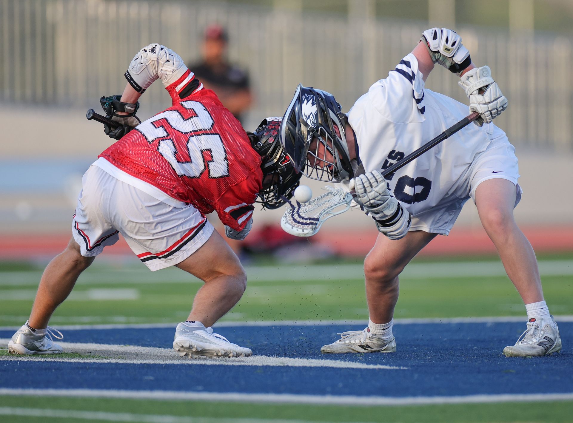 Lacrosse players in red and white uniforms battling for possession on a field. Vista Athletic Boosters