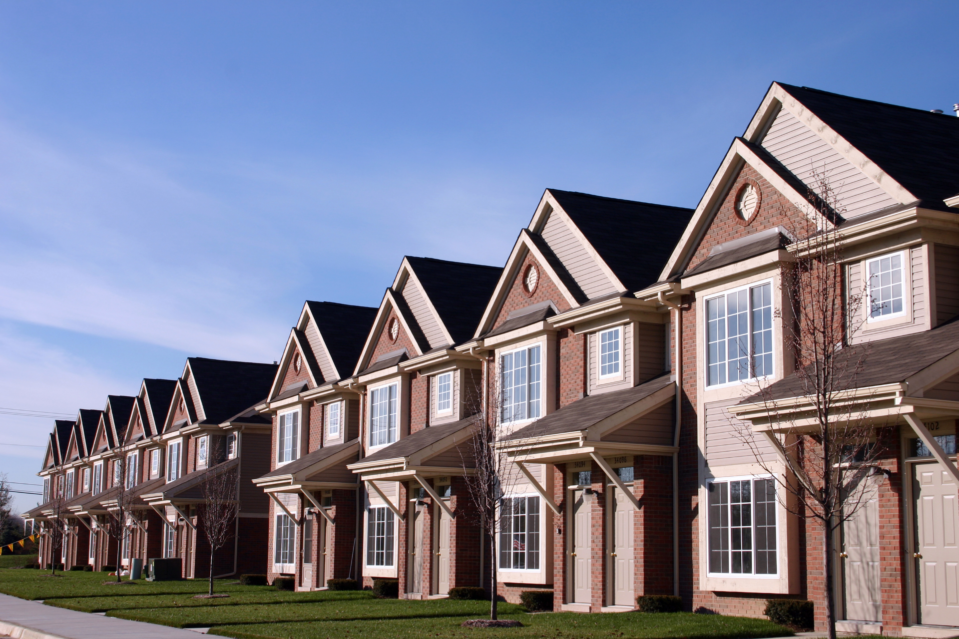 A row of houses with a blue sky in the background