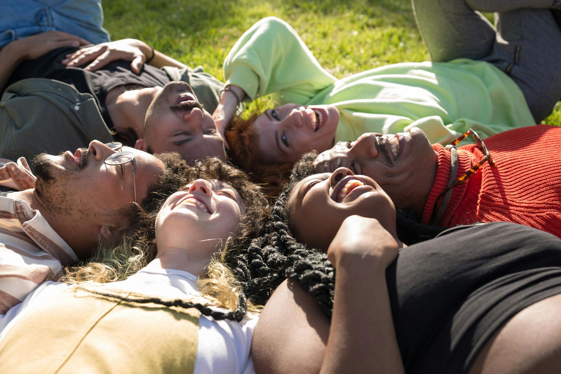 Three women are laying on a blanket in the grass in Monroe NJ