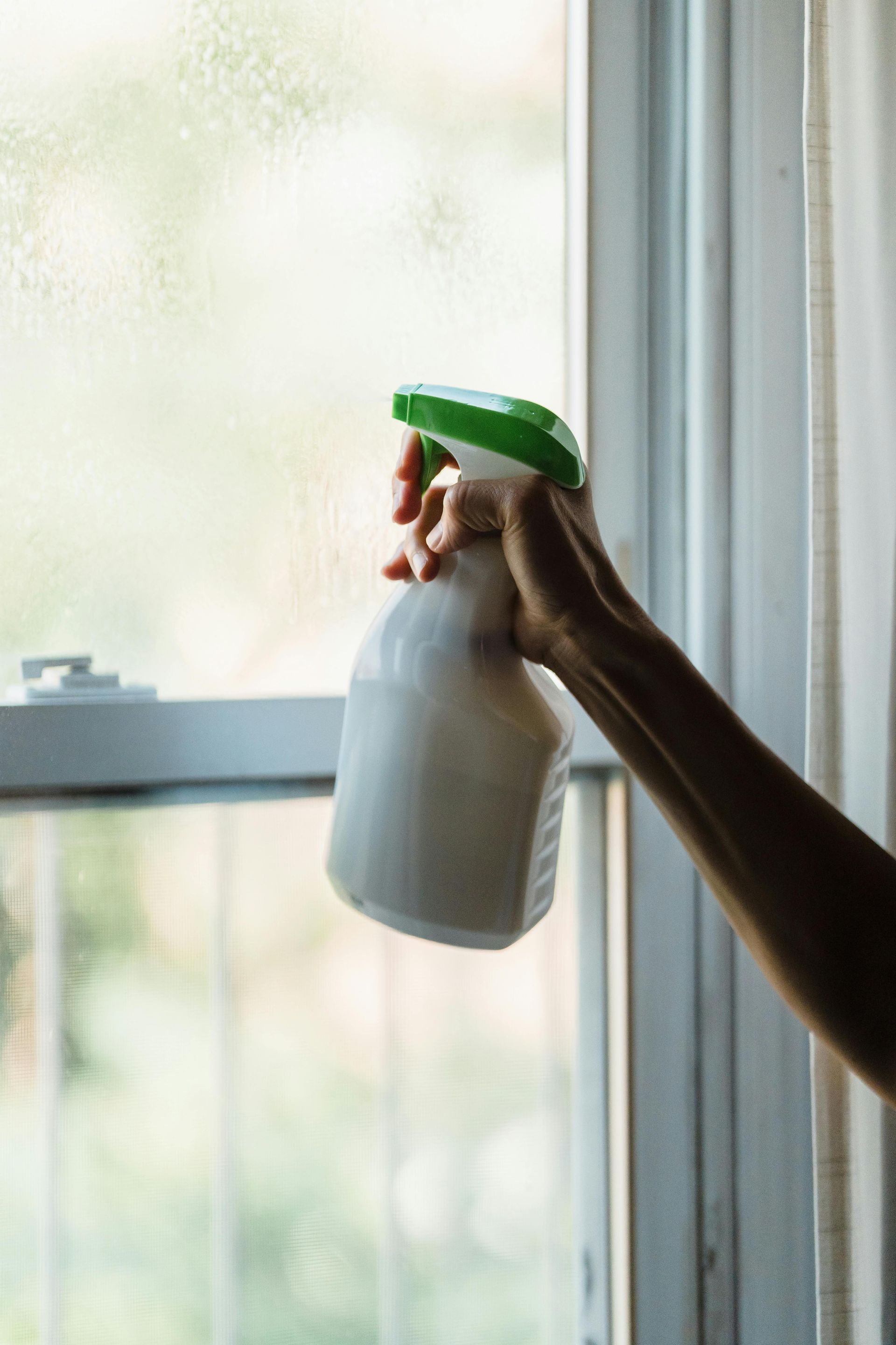 Squeegee in action: man cleaning a casement window in Middletown, New Jersey.07748