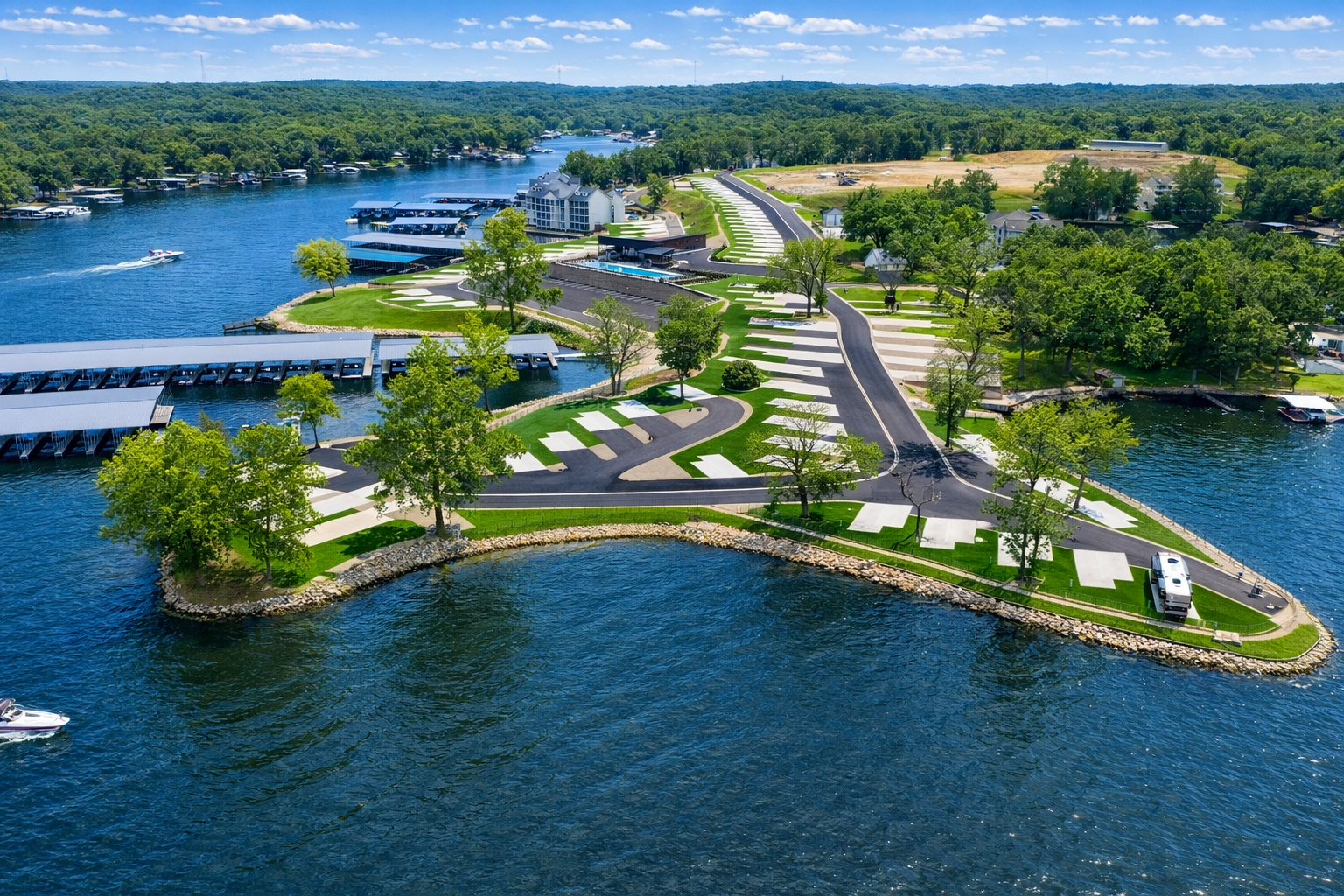 Aerial view of a resort with a pool, docks, and RV parking along a waterfront.