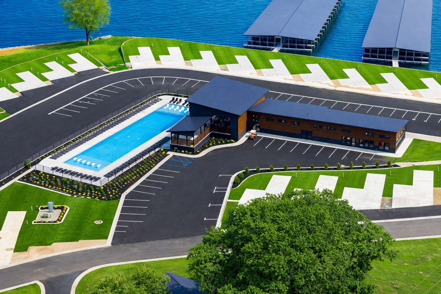 A modern building with pool and parking by a lake with boat docks.