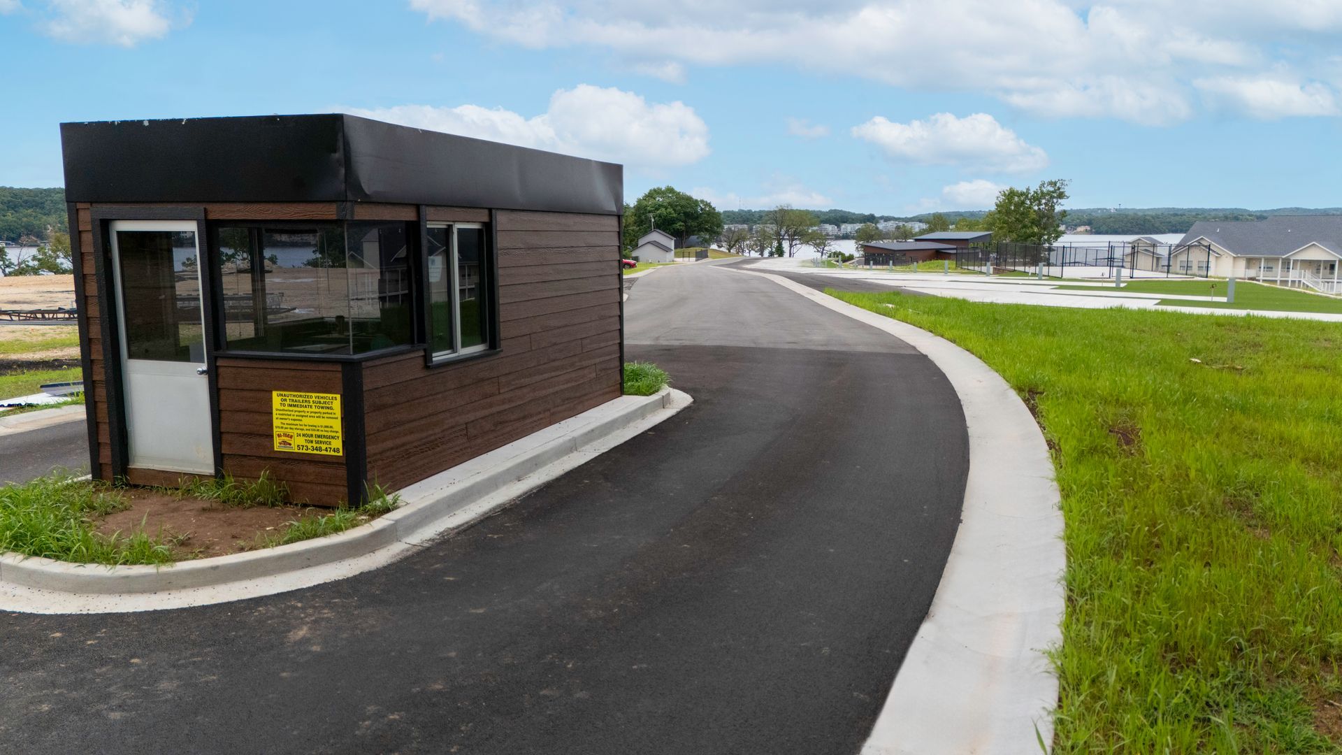 Guard house at a gated community entrance with a new asphalt road.