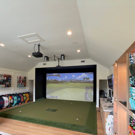 A golf ball and a golf club are laying in the grass on a golf course.