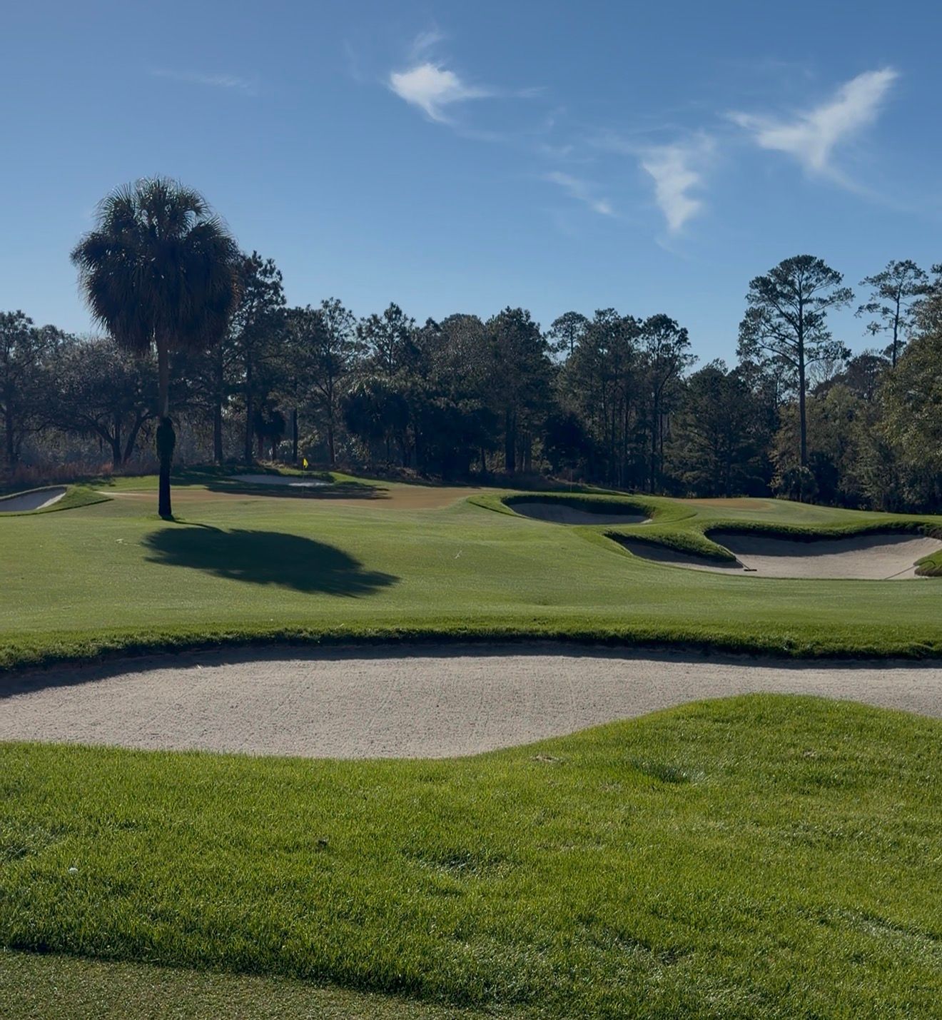A man and a girl are playing golf on a green