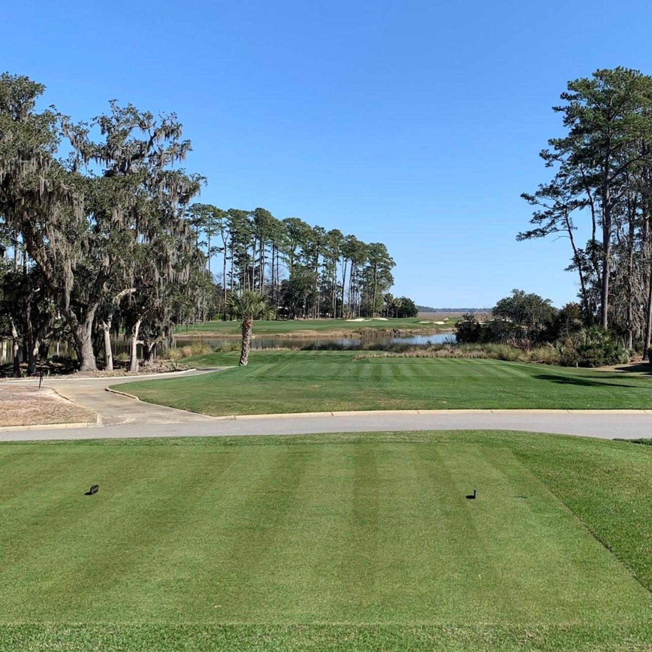 A group of golf clubs and golf balls are laying on the grass.