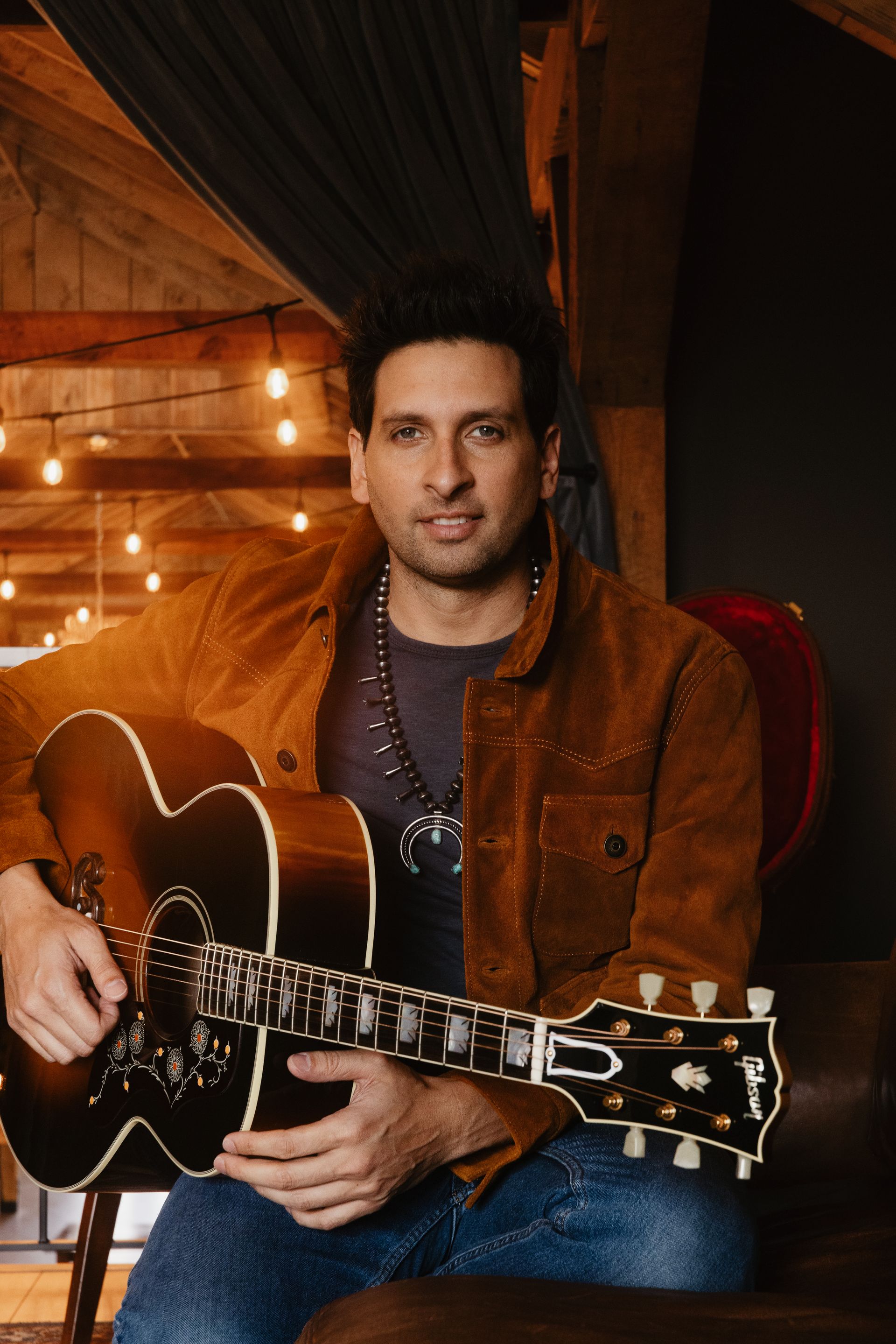 A man playing a guitar next to a woman singing into a microphone