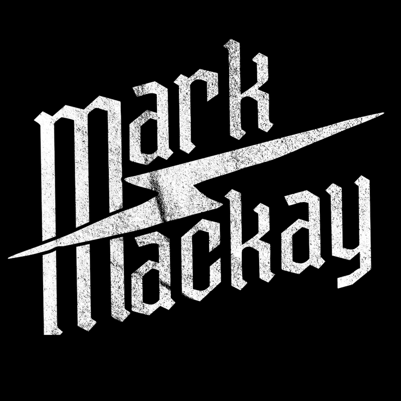 A man wearing sunglasses and a suit is standing in front of a door.