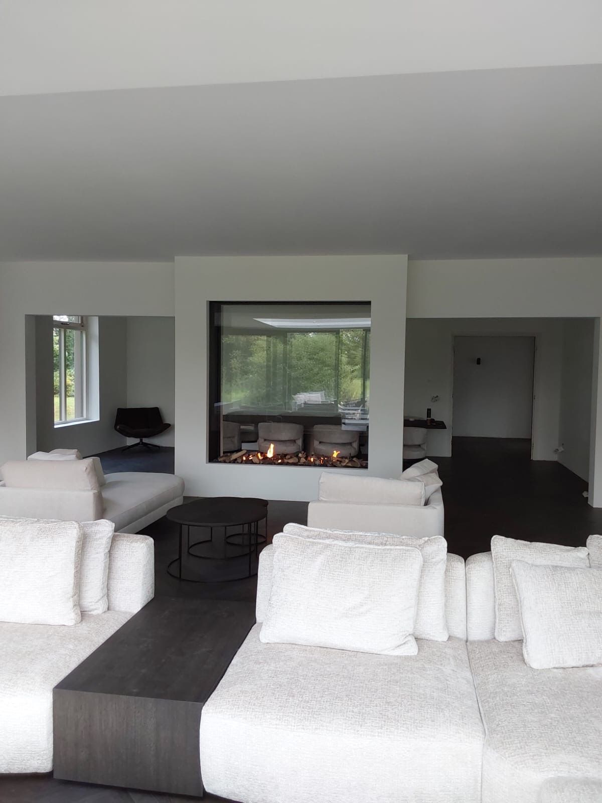 Een woonkamer met witte meubels en een open haard