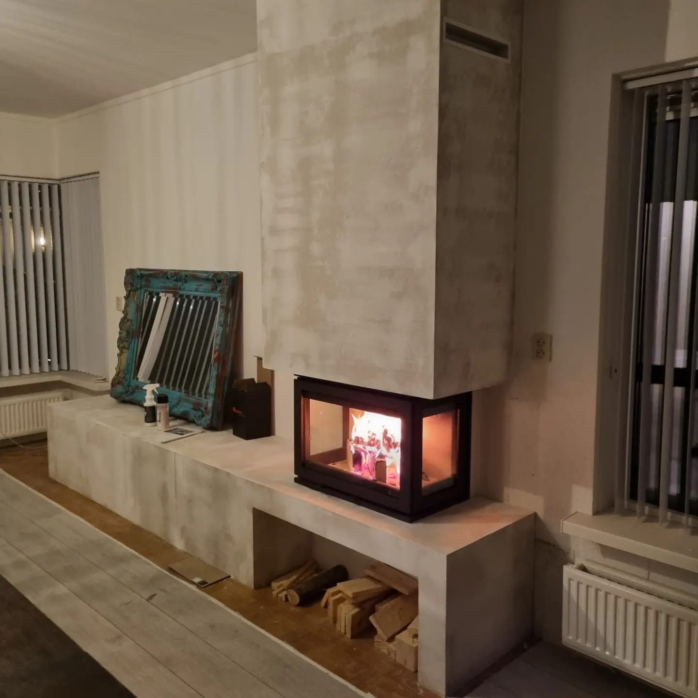 Een woonkamer met open haard en raam