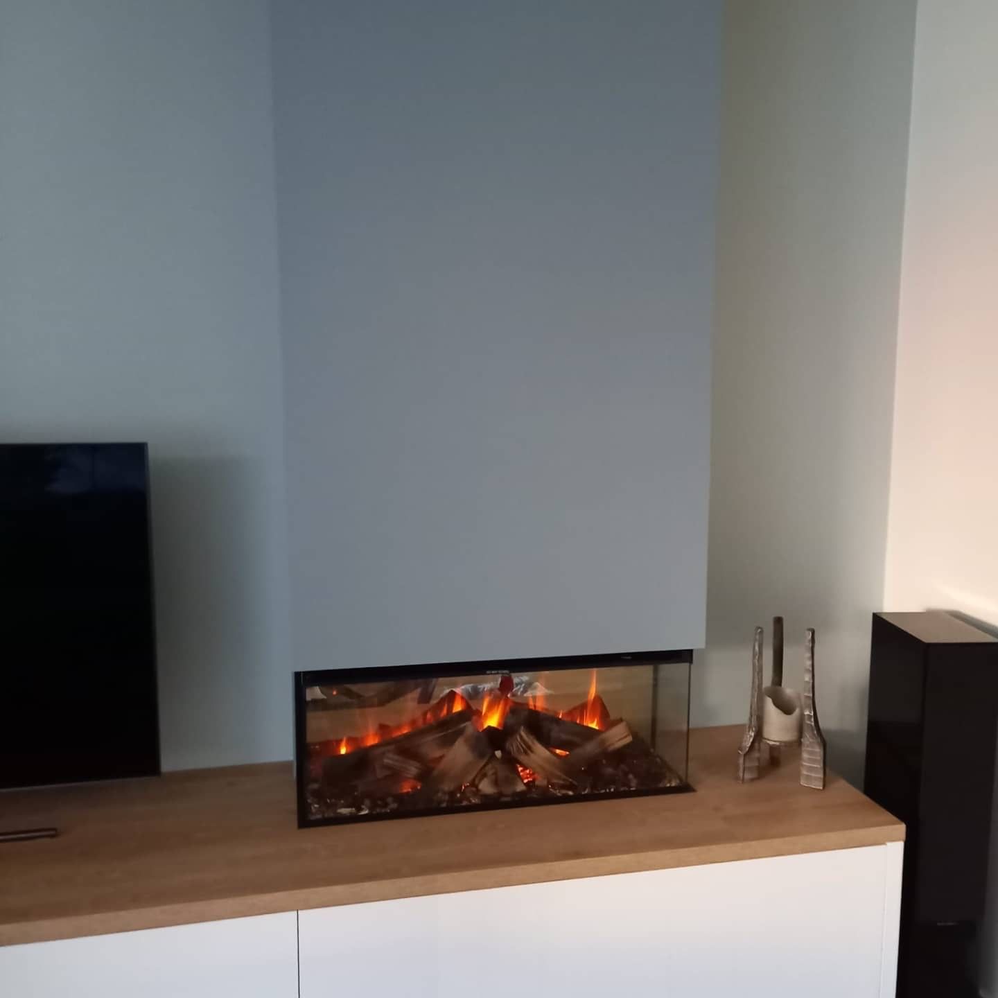 Een open haard staat op een houten tafel in een woonkamer