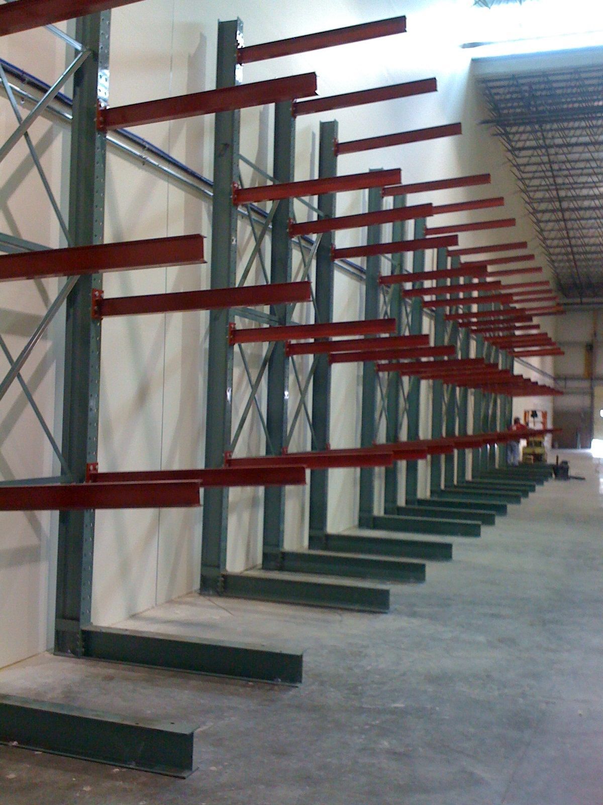 Cantilever storage racks with red arms, in a warehouse.