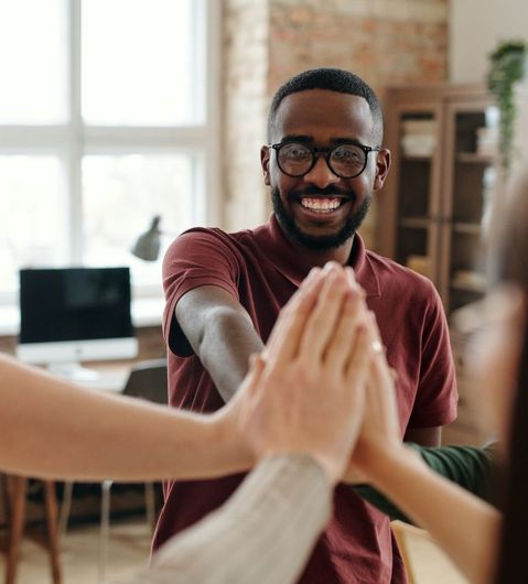 A group of people are giving each other a high five.