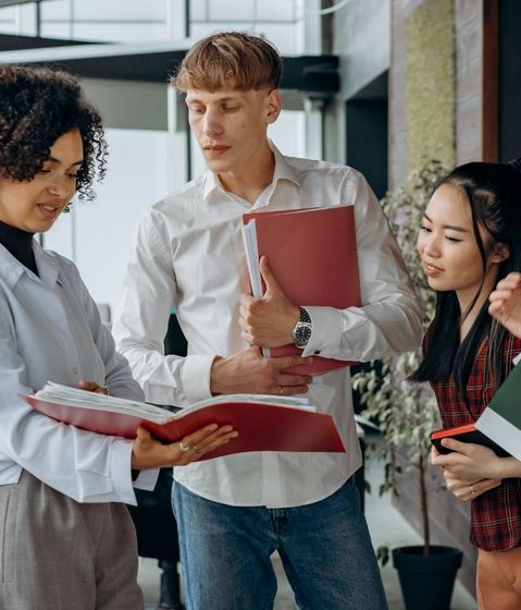 A group of people are standing next to each other holding folders.