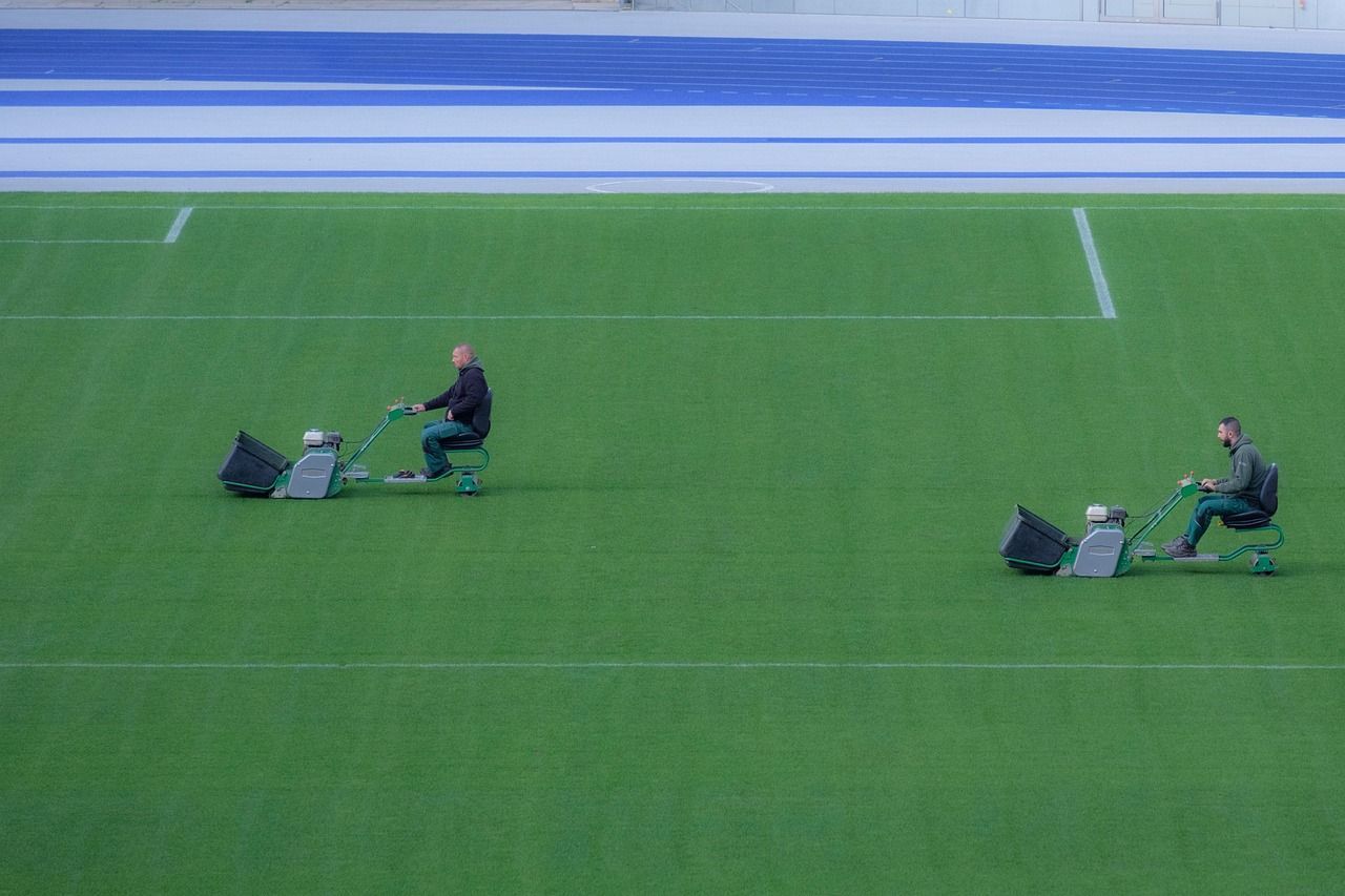 2 people mowing a football field