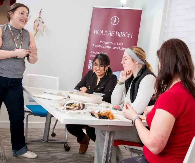 People crafting at a table with a banner that reads 